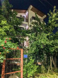 a building with a gate and trees in front of it at Villa Anastasia in Costinesti