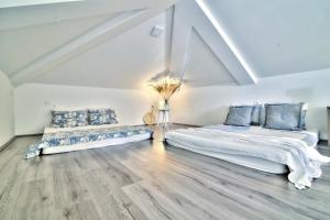 two beds in a white room with wooden floors at Dida moj in Senj