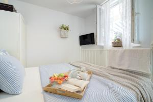 a tray of fruit on a bed in a bedroom at Dida moj in Senj