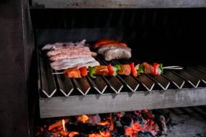 a group of meats and vegetables cooking on a grill at Hotel Casa Palacio in Montanejos