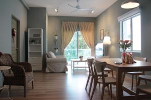 a living room with a table and chairs and a couch at The Quintet, Tower Ethel in Tanah Rata