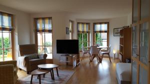 a living room with a tv and a table and chairs at Suite mit Parkplatz Gebertingen in Gebertingen