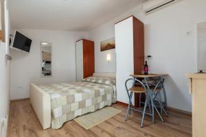 une petite chambre avec un lit et une table dans l'établissement Apartments Elita, à Rovinj