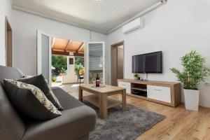 un salon avec un canapé et une télévision dans l'établissement Apartments Elita, à Rovinj