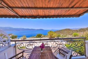 a balcony with a wooden table with flowers on it at Hamarat Otel in Kaş