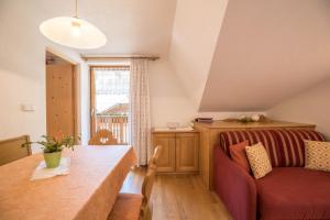 ein Wohnzimmer mit einem Sofa und einem Tisch in der Unterkunft Apartment Kornblume - Mesnerhof in Sand in Taufers