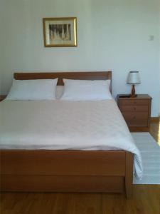 a bedroom with a large white bed and a nightstand at Rooms Katica in Korčula