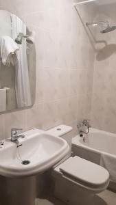 biała łazienka z toaletą i umywalką w obiekcie Casa Fuentes w mieście Poio