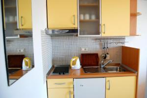 a kitchen with yellow cabinets and a sink at Studio Ante in Brela