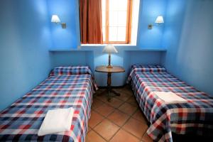 two beds in a room with blue walls and a window at Duplex 6 pax con Wifi en Bahia Sur con parking y piscinas comunitarias in San Fernando +27 photos