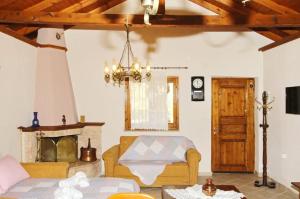 a living room with a couch and a fireplace at Panos Cottage in Koinyra
