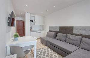a living room with a couch and a kitchen at Apartament Bella Mare z basenem in Łukęcin