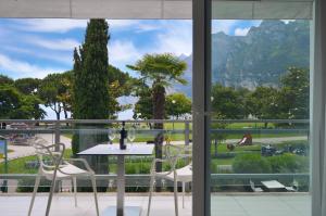 una mesa y sillas frente a una ventana en Club Nautico - Phoenix Studio Lake View, en Riva del Garda