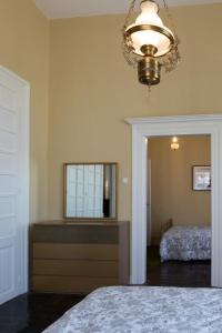 a bedroom with a bed and a mirror and a chandelier at Mora Valisi in Nafplio