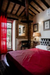 1 dormitorio con cama roja y ventana en Convento Di San Martino in Crocicchio, en Urbino