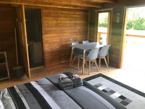 a bedroom with a table and chairs in a cabin at Old Mill House Log Cabins in Dorchester