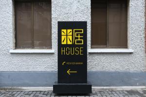 a black and yellow sign in front of a building at MIJU HOUSE Jingan-a quiet old house in downtown-flavor of life in Shanghai alley in Shanghai
