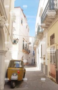 a yellow car parked in a alley between buildings at Casa Ombry Gallipoli in Gallipoli