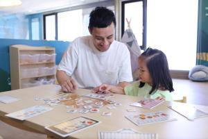 a man and a little girl playing a game at a table at Lakeshore Hotel Hualien in Hualien City +41 photos