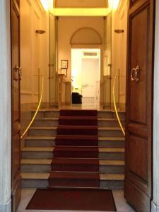 einen Flur mit einer Treppe, die zu einer weißen Tür führt in der Unterkunft Hotel Astoria Garden in Rom