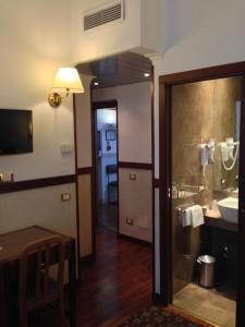 uma casa de banho com um lavatório e uma cabina de duche em vidro. em Hotel Astoria Garden em Roma