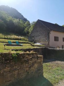 two blue chairs sitting in a field next to a building at Gîte des 3 vallées in Baume-les-Messieurs