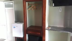 a kitchen with a cupboard and a refrigerator at Pousada Aruanã in Soure