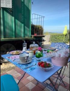 una mesa azul con platos de comida. en Une roulotte à la campagne en Saint-Just-et-Vacquières