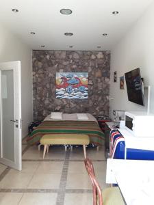 a bedroom with a bed and a stone wall at Soba Bosa in Opatija