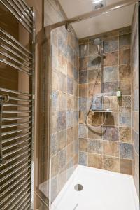a bathroom with a shower with a glass door at The Sail House in Wighton