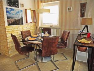 a dining room with a table and chairs at FERIENWOHNUNG DEICHWIESE SYLT-WESTERLAND 2-5 Personen-3 Schlafzimmer-Terrasse in Westerland (Sylt)
