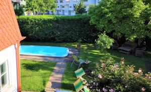 een achtertuin met een zwembad en enkele stoelen bij Christl - Apartment mit Garten und Pool zur Mitbenutzung in Wenen