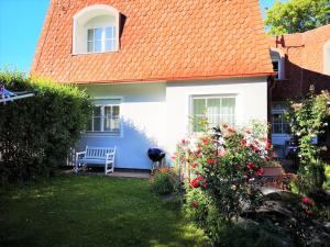 a house with an orange roof and a bench in the yard at Christl - Apartment mit Garten und Pool zur Mitbenutzung in Vienna