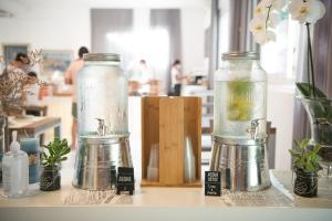 two glass jars sitting on a table with plants at HOTEL VIENNA "Casa di viaggiatori per viaggiatori" in Cervia