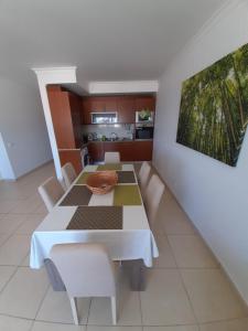 アルマカオ・デ・ペラにあるEdificio Praia Mar Solのダイニングルーム(白いテーブル、椅子付)