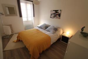 a bedroom with a bed with a yellow blanket and a window at Maison avec piscine et jardin- 4 chambres 8 pers in Cuers +17 photos