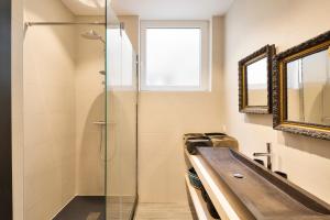 W łazience znajduje się szklana kabina prysznicowa i umywalka. w obiekcie Le Blue Note by Cocoonr - Bel appartement de standing w Saint-Malo