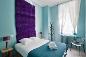 a blue bedroom with a bed with two towels on it at Le Blue Note intra-muros - Bel appartement de standing in Saint Malo
