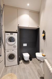 a bathroom with a washing machine and a toilet at Le Blue Note intra-muros - Bel appartement de standing in Saint Malo