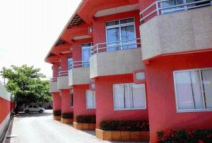 a red building with balconies on the side of it at Pousada Abais in Aracaju