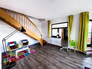 ein Wohnzimmer mit einer Treppe und gelben Vorhängen in der Unterkunft apartHOTEL Magdeburg in Magdeburg