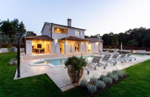 a house with a pool and chairs in the yard at Mirana Luxury Villas in Kavran