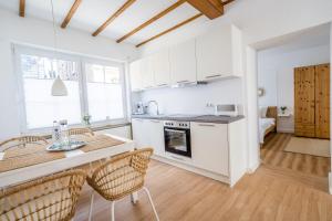 a kitchen with white cabinets and a table and chairs at Pension Herheinspaziert in Bad Breisig