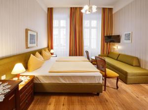 ウィーンにあるホテル オーストリア - ウィーンのベッドとソファ付きのホテルルーム