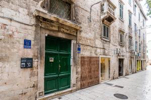 una puerta verde al lado de un edificio en Palace Tartaglia, en Split