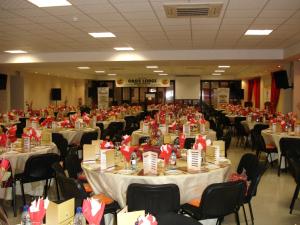 un salón de banquetes lleno de mesas y sillas con arcos rojos en Oasis Hotel, en Mokopane