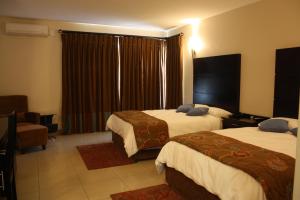 una camera d'albergo con due letti e una finestra di Oasis Hotel a Mokopane