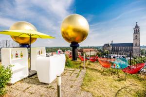 un jardín en la azotea con sillas y sombrilla en apartHOTEL Magdeburg en Magdeburgo