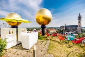 einen Dachgarten mit Stühlen und einem Sonnenschirm in der Unterkunft apartHOTEL Magdeburg in Magdeburg
