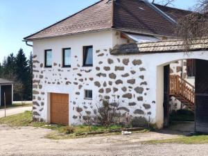 a white house with a brown roof and a garage at Biohof Obereibensteiner in Kaltenberg